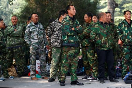 Uniformed people take part in a protest outside the Bayi Building, a major Chinese military building in Beijing, China, October 11, 2016. REUTERS/Thomas Peter