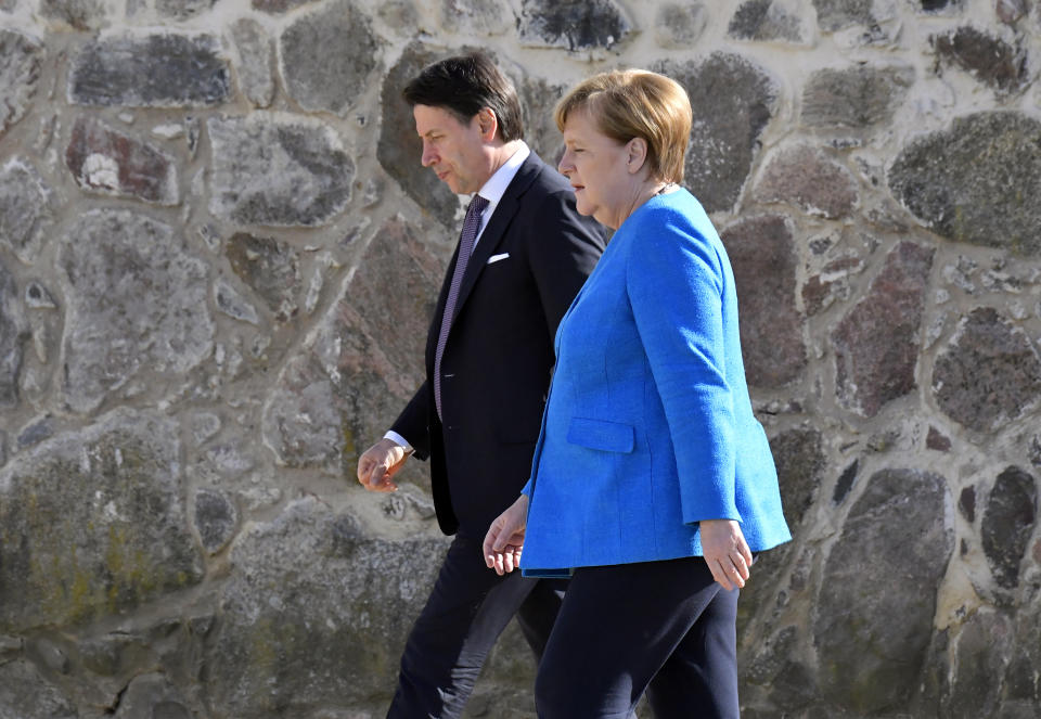 German Chancellor Angela Merkel and Italian Prime Minister Giuseppe Conte walk to attend a press conference in the garden of the German governmental guest house in Meseberg, outside Berlin, Monday, July 13, 2020. (Tobias Schwarz/Pool photo via AP)