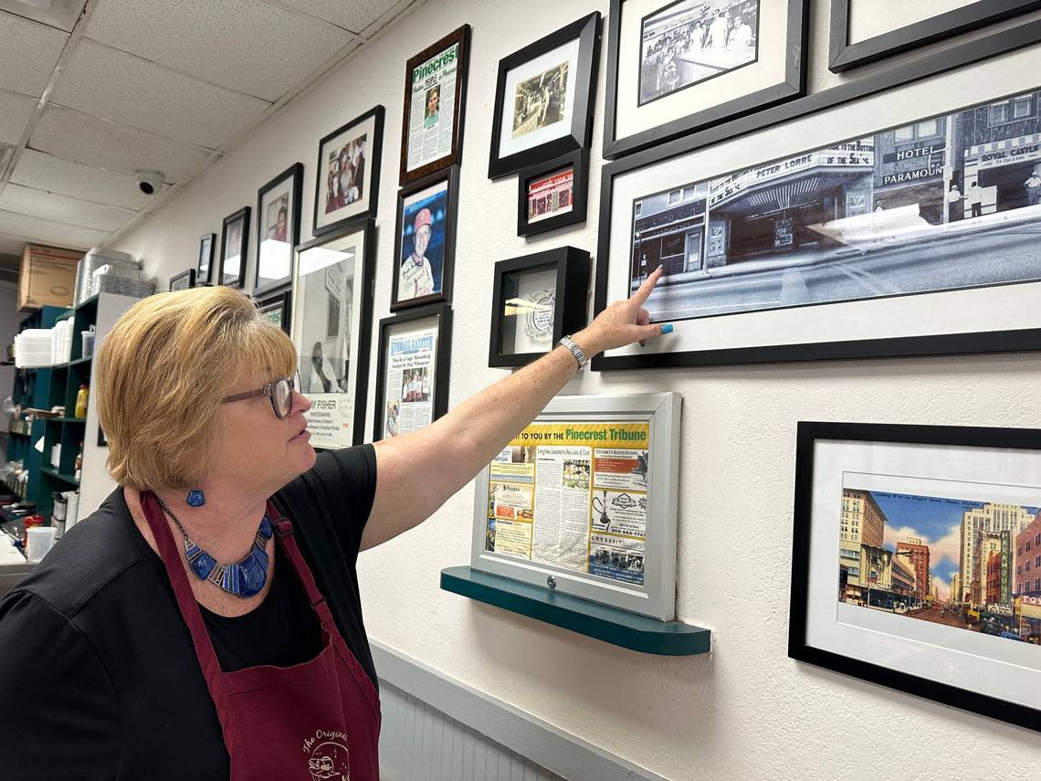 Tonya Gay, a veteran waitress at Lots of Lox in Palmetto Bay, points to a photo of the old Paramount Soda Shop that was on Southeast First Avenue and First Street in downtown Miami in the 1940s and ’50s. James Poulos owned the eatery. His grandsons Nick and Steve were co-owners of Lots of Lox. Howard Cohen/hcohen@miamiherald.com