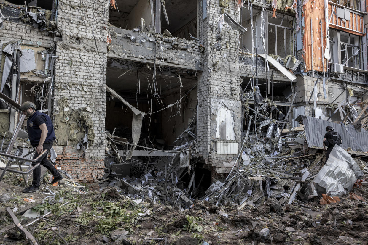 Personal de emergencia en un edificio atacado por Rusia en la ciudad de Járkov, al noreste de Ucrania, que está a solo 32 kilómetros de la frontera rusa, el 25 de mayo de 2024. (Finbarr O’Reilly/The New York Times)