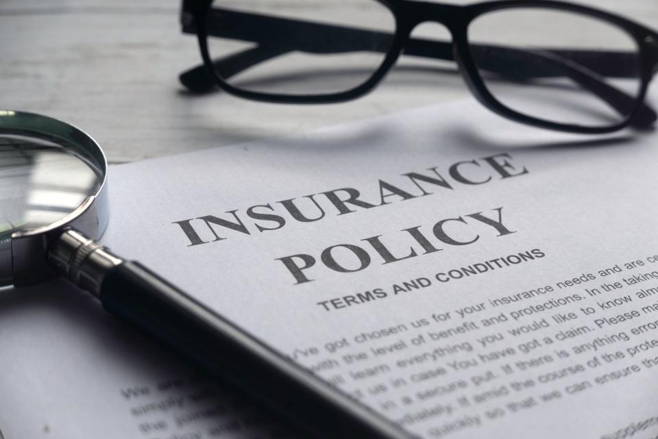 Insurance policy with glasses and a magnifying glass on it.