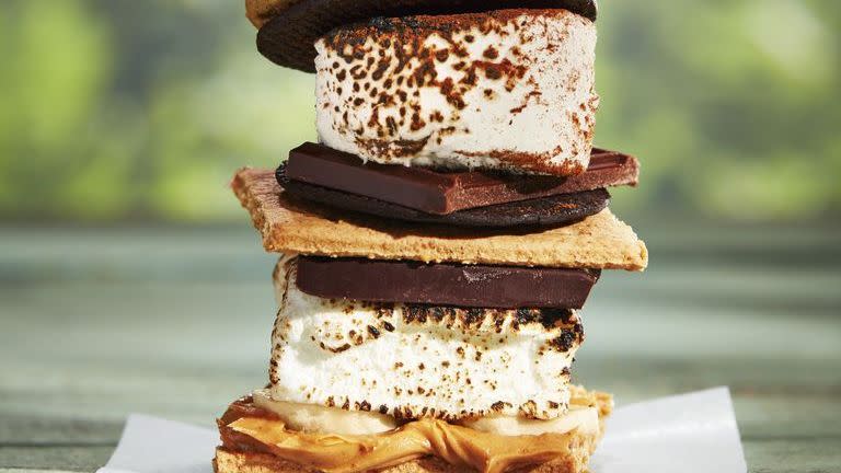 three different types of smores stacked on top of each other on a wooden table outside
