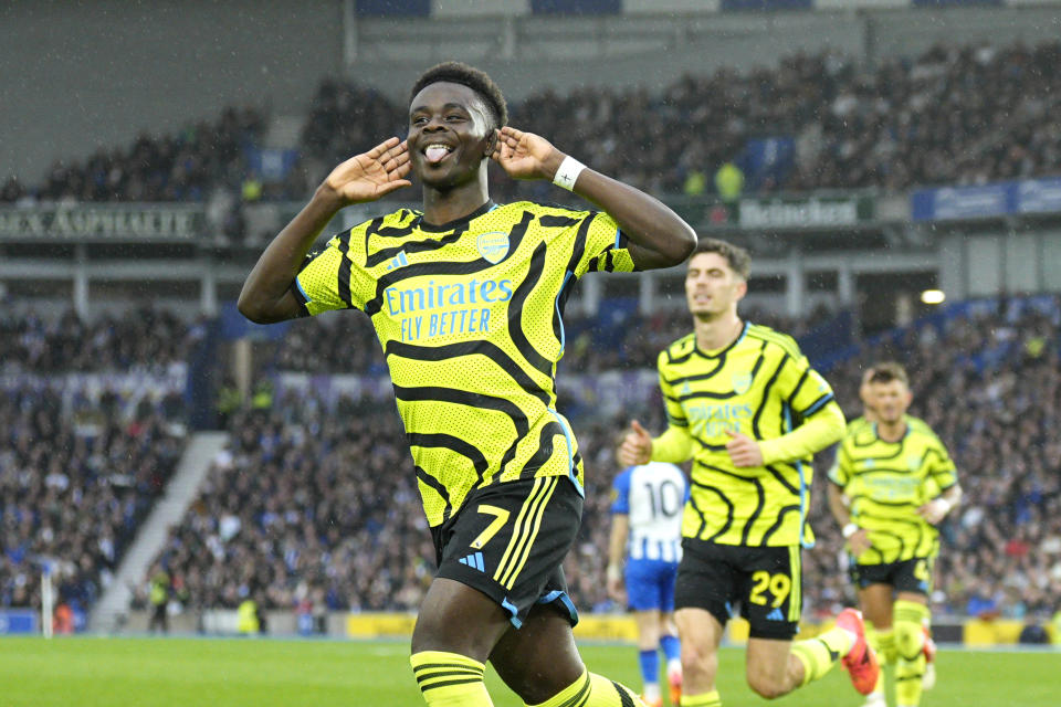 Arsenal's Bukayo Saka celebrates after scoring his side's opening goal during the English Premier League soccer match between Brighton and Hove Albion and Arsenal at the American Express Community Stadium in Brighton, England, Saturday, April 6, 2024. (AP Photo/Dave Shopland)