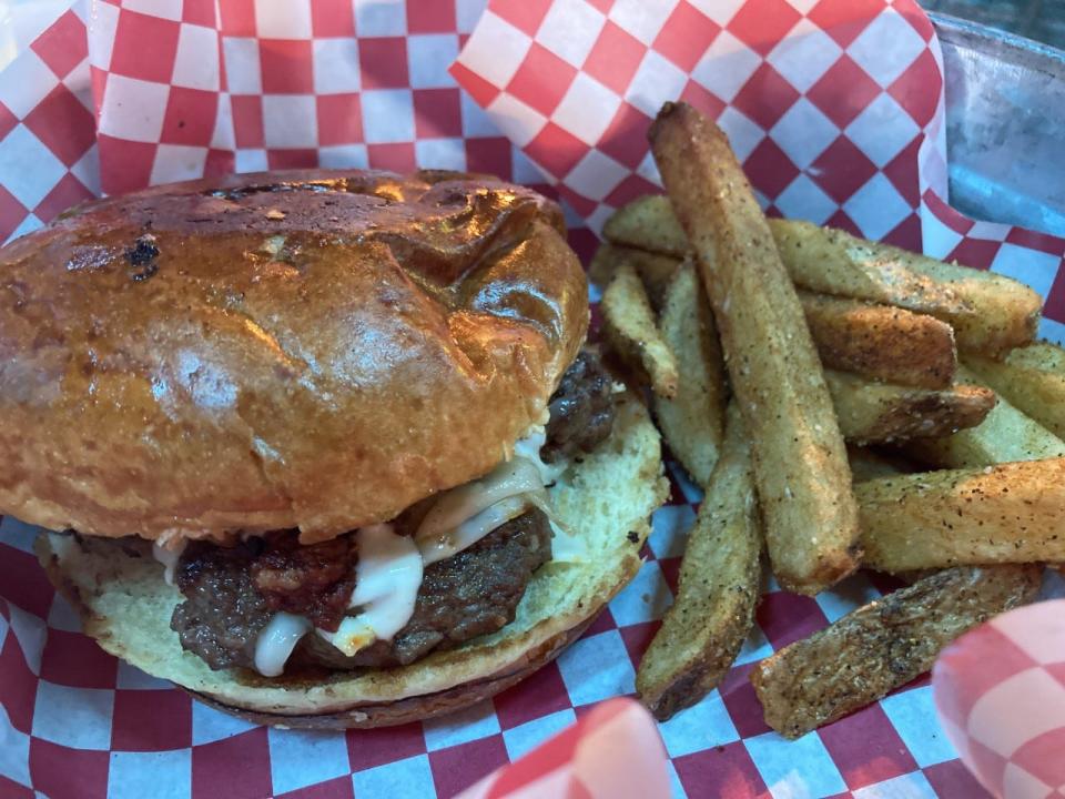 The Friendz Chuco Burger is a ground beef patty grilled with muenster cheese and smoky chorizo and is served inside warm, soft buns.