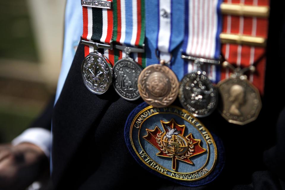 A Canadian veteran soldier who served with the United Nations Peacekeeping force on war-divided Cyprus displays his medals at a cemetery for fallen Canadian and British soldiers inside the UN-controlled buffer zone on the outskirts of the capital Nicosia on Tuesday, March 18, 2014. Thousands of soldiers from 32 countries have donned the UN blue beret in Cyprus over half a century in what has become the longest serving peacekeeping force of its kind. Some 178 lost their lives there. (AP Photo/Petros Karadjias)