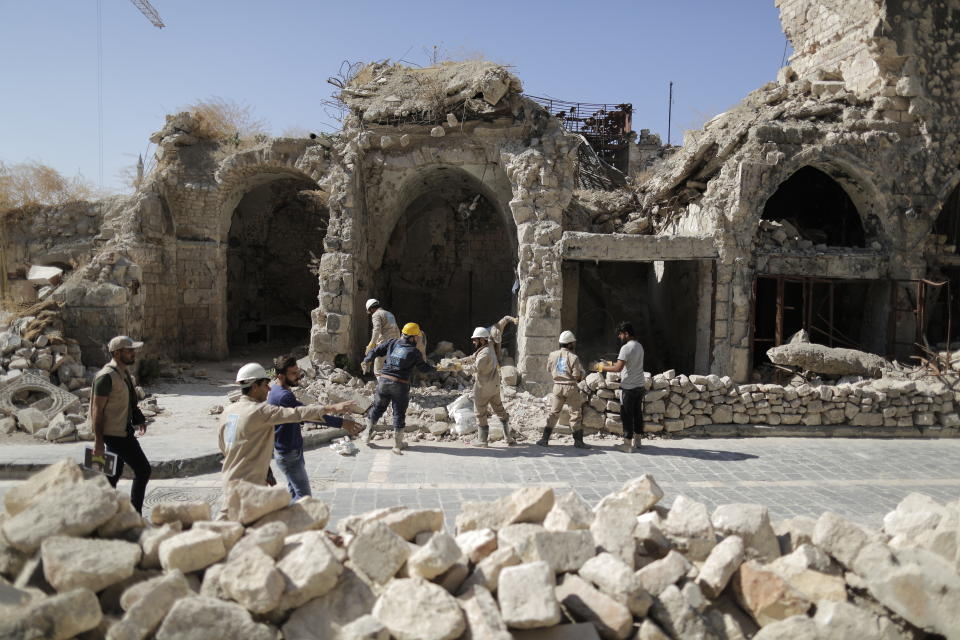 In this Saturday, July 27, 2019 photo, workers remove rubble from a damaged shop in the old city of Aleppo, Syria. Syrians say it’s even harder now to make ends meet than it was during the height of their country’s civil war because of intensified U.S and European sanctions. Prices have leaped because of restrictions on oil imports, the value of the currency has plunged in recent months. Most of the country is now below the poverty line, earning less than $100 a month. (AP Photo/Hassan Ammar)