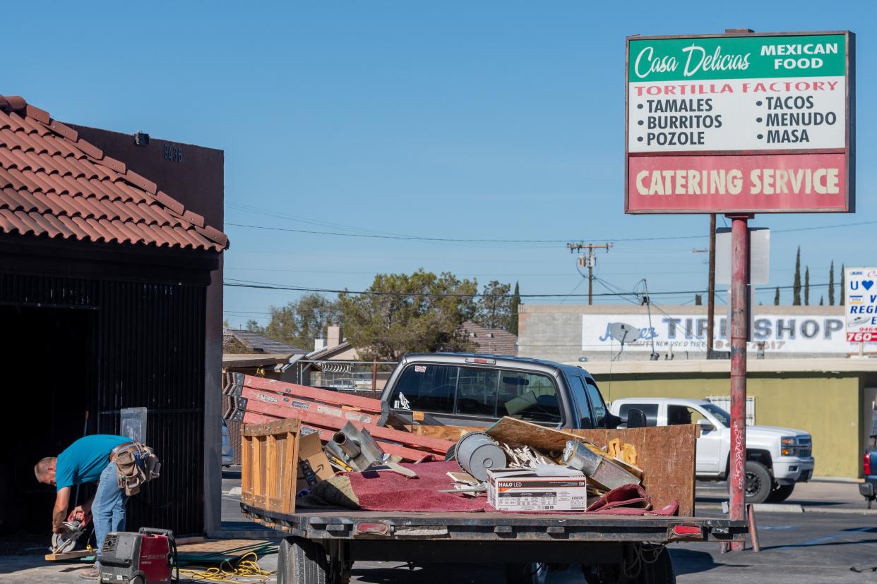 A worker saws a board in front of Casa Delicias in Hesperia after an early morning fire damaged the restaurant on Wednesday, Nov. 10, 2021.