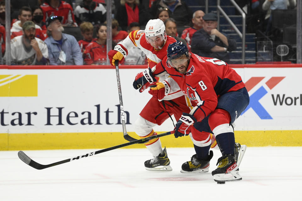 Washington Capitals left wing Alex Ovechkin (8) battles for the puck with Calgary Flames center Dillon Dube (29) during the second period of an NHL hockey game, Saturday, Oct. 23, 2021, in Washington. (AP Photo/Nick Wass)