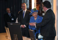 Britain's Queen Elizabeth looks at artefacts as she meets with GCHQ Director Jeremy Fleming and historian Tony Comer during her visit at the Watergate House to mark the centenary of the GCHQ (Government Communications Head Quarters) in London, Britain, February 14, 2019. REUTERS/Hannah McKay/Pool