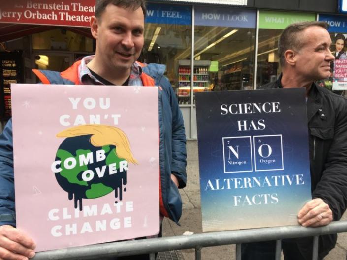 Two Science March demonstrators hold up their signs. 