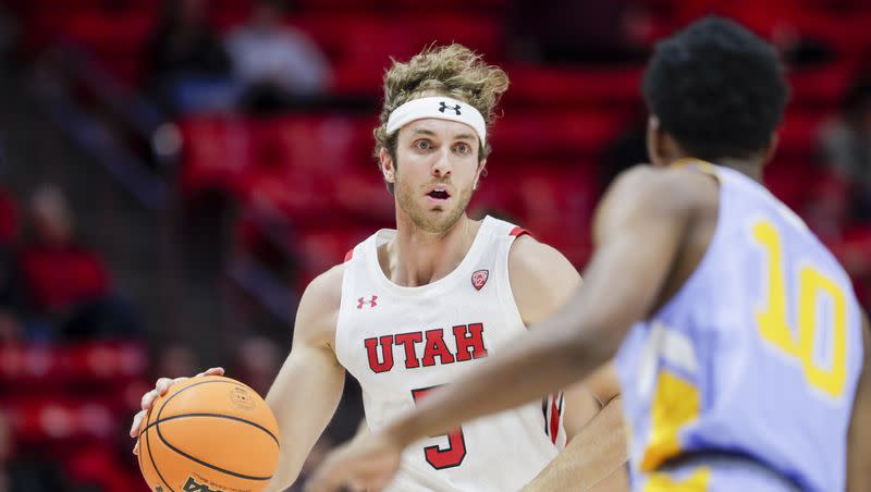 Utah Runnin’ Utes Jaxon Brenchley (5) carries the ball down the court while being defended by the Long Island Sharks’ R.J. Greene (10) during a game at the Huntsman Center in Salt Lake City on Monday, Nov. 7, 2022. Brenchley announced Tuesday he will enter the NCAA transfer portal as a graduate transfer.