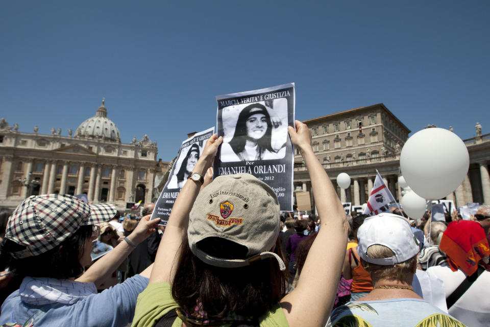 FILE - In this Sunday, May 27, 2012 file photo, people hold pictures of Emanuela Orlandi reading, "march for truth and justice for Emanuela" in St. Peter's square, at the Vatican. An expert for the family of a Vatican teenager who went missing in 1983 says there are thousands of bones in an underground space near a Vatican cemetery. Giorgio Portera, engaged by Emanuela Orlandi’s family, said the extent of the cache emerged Saturday when Vatican-appointed experts began cataloguing the remains discovered on July 13. Portera said skulls and bones appear to belong to dozens of individuals. The Vatican made no mention of the number but said analyses would resume on July 27. (AP Photo/Andrew Medichini, File)