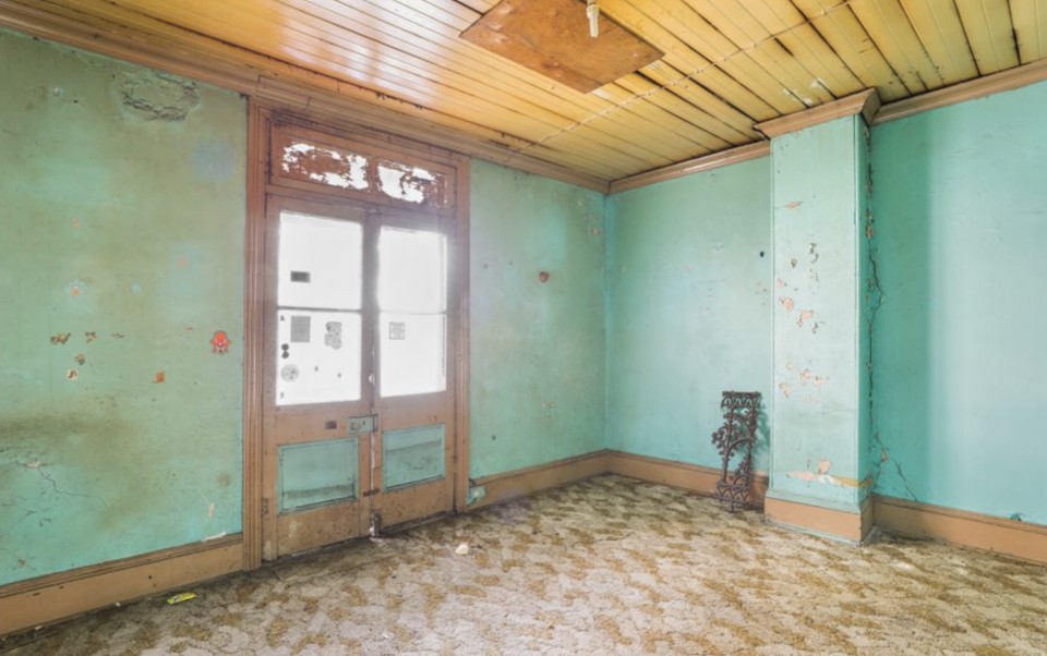 The inside of a Waterloo home in Sydney is seen with paint coming off the walls.