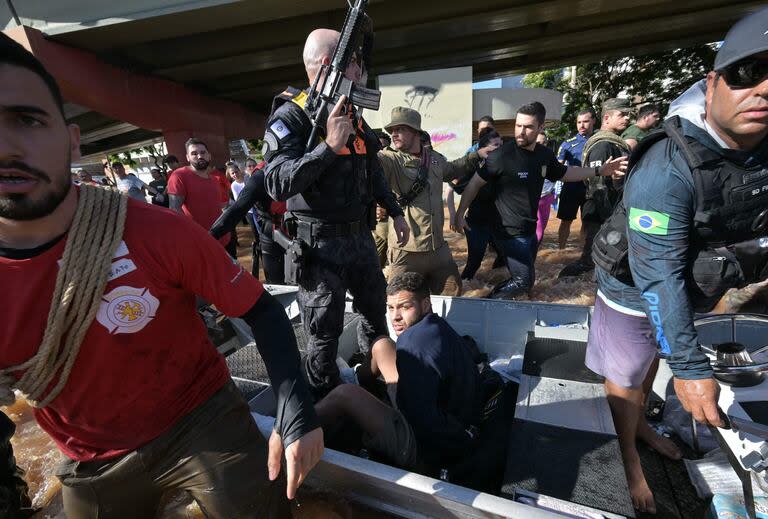 Las fuerzas de seguridad custodian a un hombre arrestado por presuntamente robar casas tras las inundaciones provocadas por las fuertes lluvias en Porto Alegre, estado de Rio Grande do Sul, Brasil, el 6 de mayo de 2024.