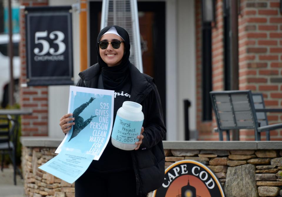 Mashpee High School junior Ayesha Shafi, 16, holds a sign and collection container along the walk route. "Walk for Water" was held Sunday morning. Mashpee Commons hosted Mashpee High School Key Club's fundraising event.