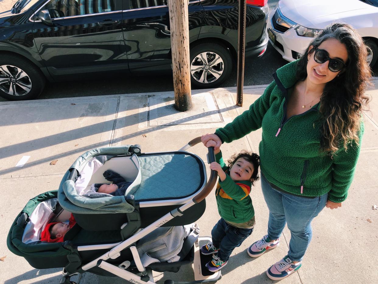 Mom pushing stroller with three kids