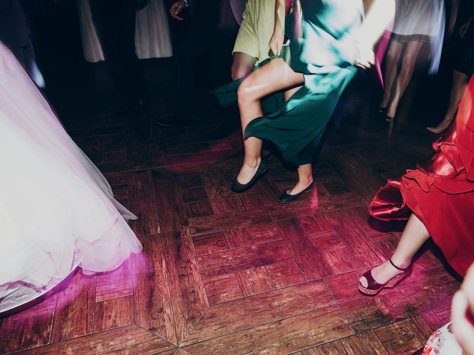 View of people from knees down on a wooden dance floor