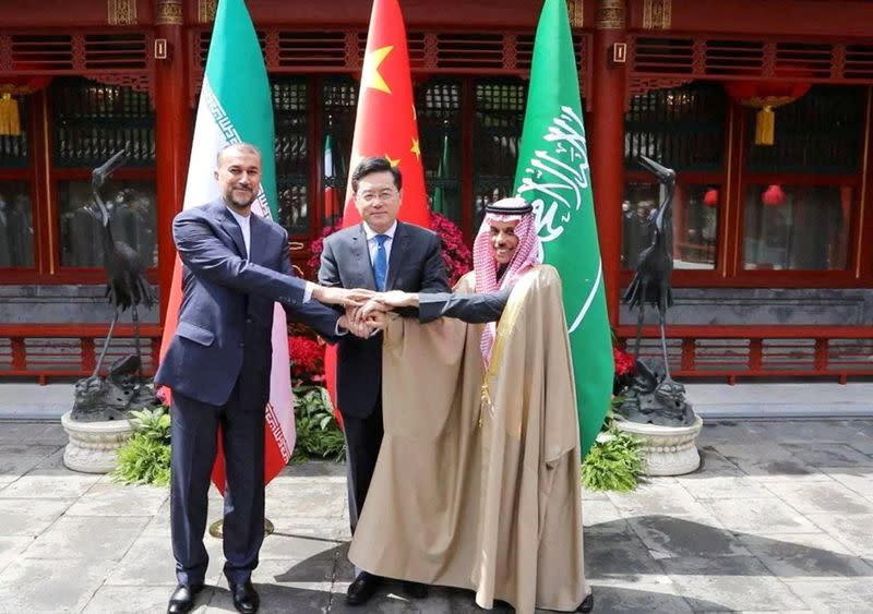 El ministro iraní de Asuntos Exteriores, Hossein Amir-Abdollahian, y el ministro saudí de Asuntos Exteriores, el príncipe Faisal bin Farhan Al Saud, y el ministro chino de Asuntos Exteriores, Qin Gang, se dan la mano durante una reunión en Pekín, China