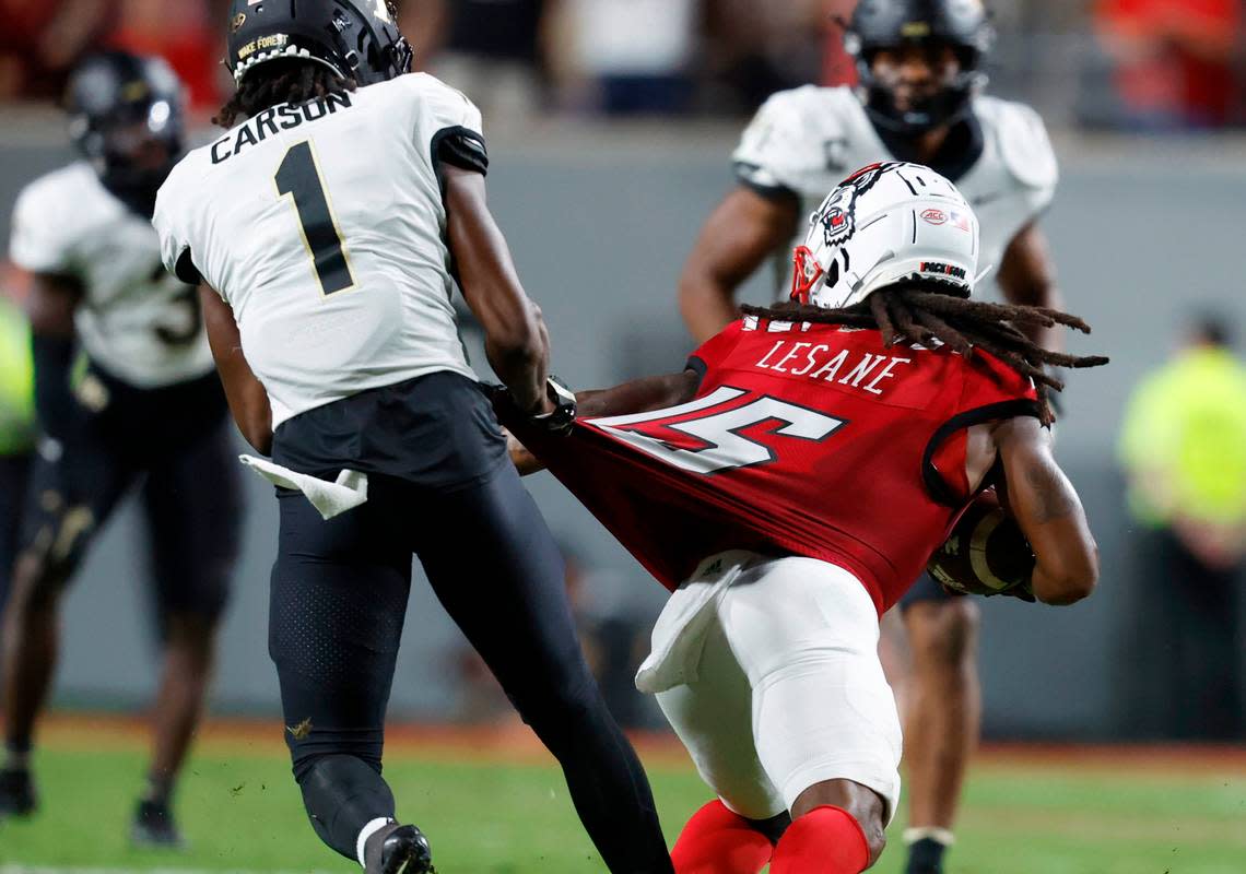 Wake Forest defensive back Caelen Carson (1) pulls on the uniform of N.C. State wide receiver Keyon Lesane (15) to try to tackle him during the second half of N.C. State’s 30-21 victory over Wake Forest at Carter-Finley Stadium in Raleigh, N.C., Saturday, Nov. 5, 2022.