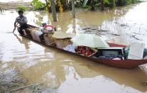 A man rows a boat carrying his belongings through flood waters after heavy rainfall due to typhoon Haiyan in Shangsi county, Guangxi Zhuang autonomous region November 11, 2013.