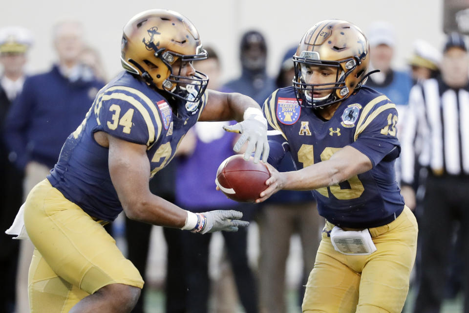 Navy quarterback Malcolm Perry (10) hands off to fullback Jamale Carothers (34) in the first half of the Liberty Bowl NCAA college football game against Kansas State Tuesday, Dec. 31, 2019, in Memphis, Tenn. (AP Photo/Mark Humphrey)