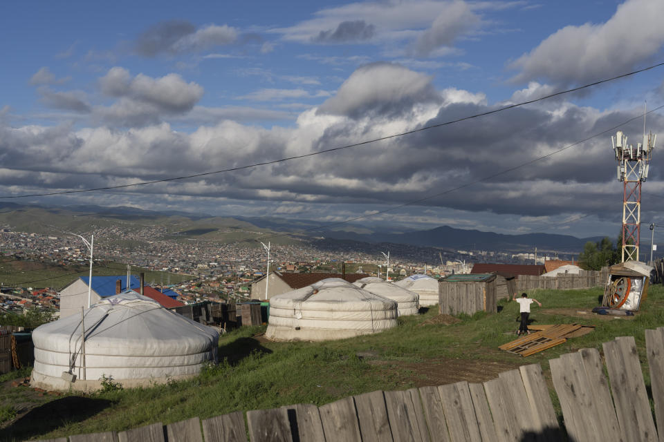 A boy runs past gers, traditional Mongolian dwelling, on the hill side of Ger fistrict on the outskirts of Ulaanbaatar, Mongolia, Thursday, June 27, 2024. (AP Photo/Ng Han Guan)