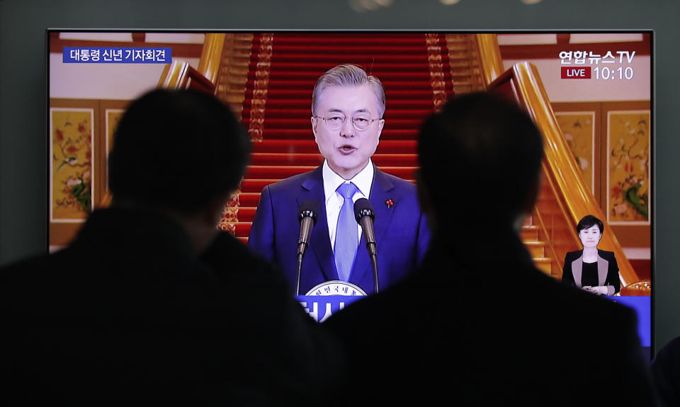 People watch a TV screen showing a live broadcast of South Korean President Moon Jae-in's New Year speech at the Seoul Railway Station in Seoul, South Korea, Thursday, Jan. 10, 2019. President Moon has suggested he'll push for sanction exemptions to restart dormant economic cooperation projects with North Korea.(AP Photo/Lee Jin-man)