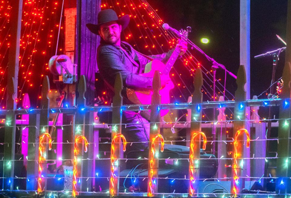 Country singer Chad Bushnell performs on the Big Valley Ford float as it rolls down Church Street in the Kiwanis Club of Greater Lodi's annual Parade of Lights in downtown Lodi on Thursday, Dec. 1, 2022. More than 80 floats washed in a sea of lights, marching bands, dance groups, and themed vehicles participated in the Lodi traditional kickoff to the Christmas season.