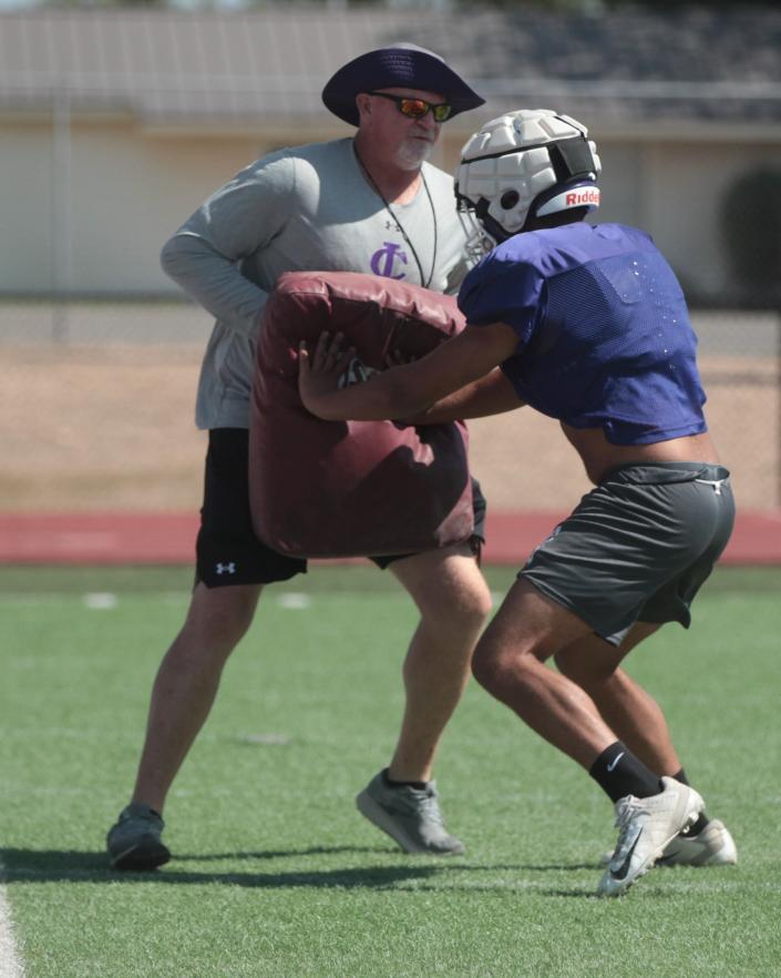 Irion County High School head football coach Don Coffell provides a blocking dummy for a player during a drill at football workout Wednesday, Aug. 3, 2022, at O.K. Wolfenbarger Field in Mertzon.