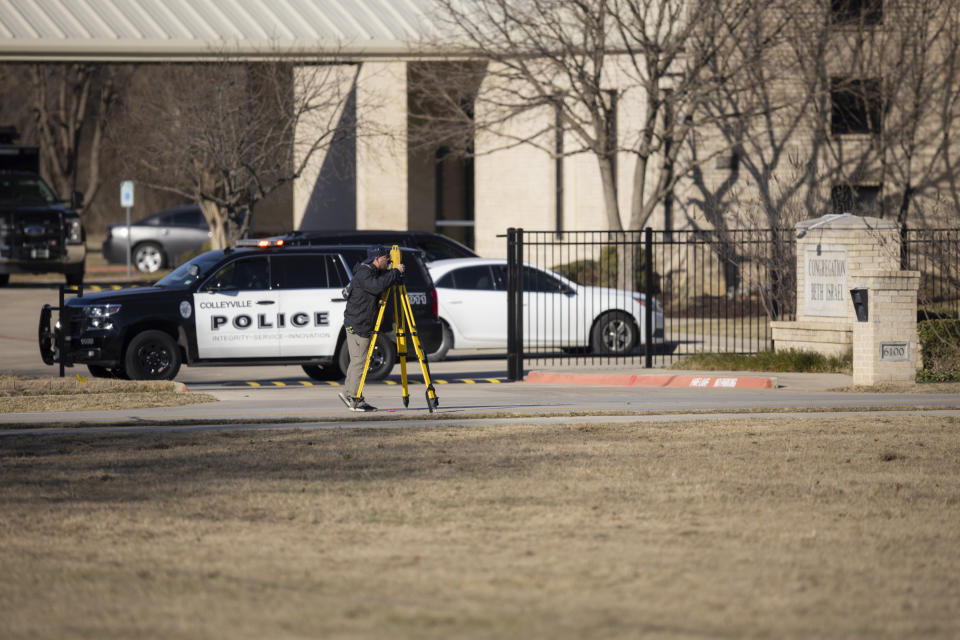 Law enforcement process the scene in front of the Congregation Beth Israel synagogue, Sunday, Jan. 16, 2022, in Colleyville, Texas. A man held hostages for more than 10 hours Saturday inside the temple. The hostages were able to escape and the hostage taker was killed. FBI Special Agent in Charge Matt DeSarno said a team would investigate "the shooting incident." (AP Photo/Brandon Wade)