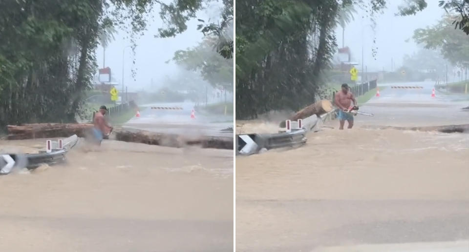 Billy Quad chopping up the fallen tree with a chainsaw while standing in floodwaters. 