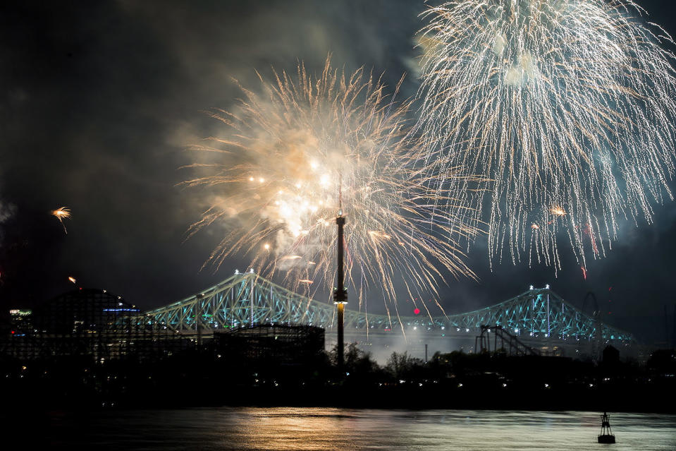 Fireworks explode over an illuminated Jacques Cartier Bridge