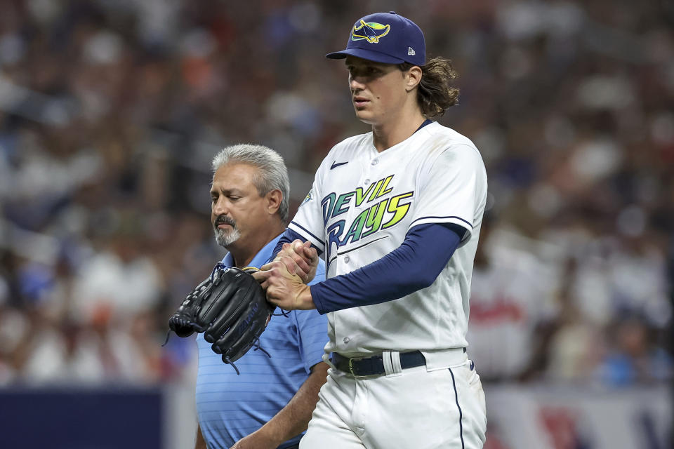 Tampa Bay Rays starting pitcher Tyler Glasnow walks off with athletic trainer Mike Sandoval after being removed during the sixth inning of the team's baseball game against the Atlanta Braves on Friday, July 7, 2023, in St. Petersburg, Fla. (AP Photo/Mike Carlson)