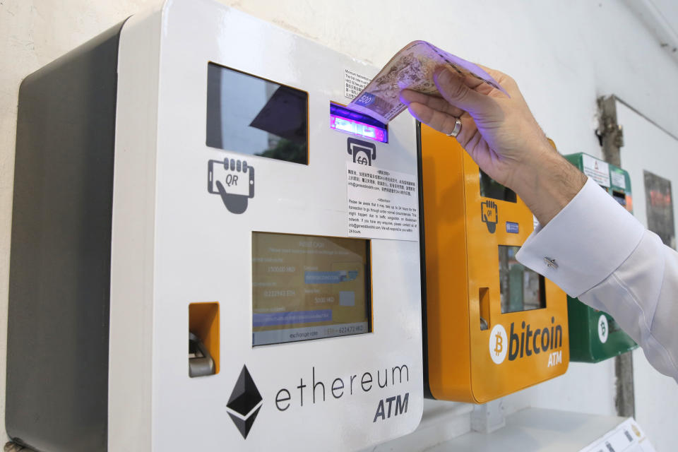 A man uses the Ethereum ATM in Hong Kong, Friday, May 11, 2018. Ethereum is one of the world's popular virtual currencies. (AP Photo/Kin Cheung)