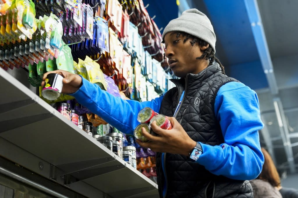 Operational lead Willie Morrow stocks shelves at Cloud 9 Cannabis as the store prepares to open, Thursday, Feb. 1, 2024, in Arlington, Wash. (AP Photo/Lindsey Wasson)