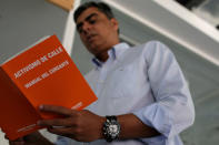 Emilio Grateron, national head of activism of Popular Will (Voluntad Popular) party, holds a copy of the book "Street activism. Participant's manual" in Caracas, Venezuela March 13, 2017. REUTERS/Marco Bello