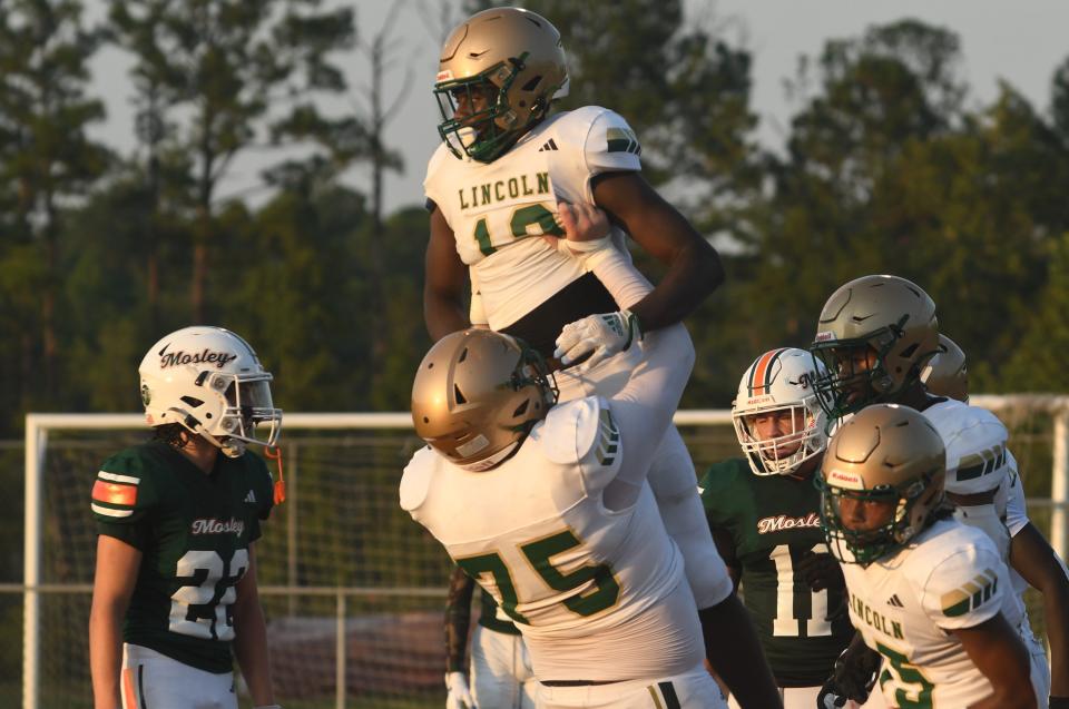 Lincoln players celebrating a touchdown against Mosley on Aug. 18