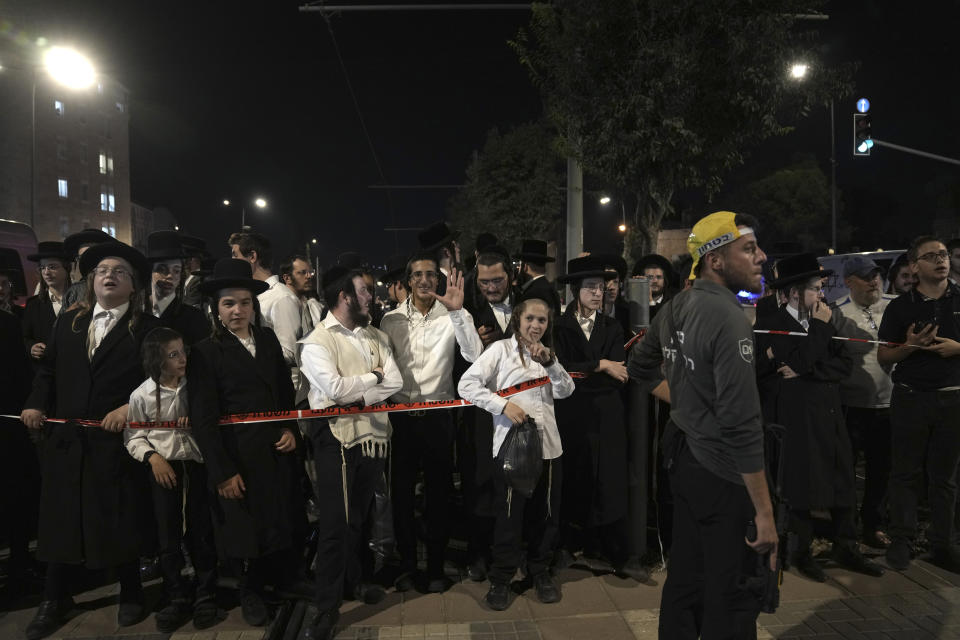 Ultra-Orthodox youth gather at a light rail train station after a stabbing in Jerusalem, Wednesday, Aug. 30, 2023. Israeli police said a Palestinian assailant stabbed an Israeli man near a light-rail station before the attacker was shot and killed by police. Israeli paramedics said the Israeli man was moderately wounded, and pronounced the attacker dead. (AP Photo/Mahmoud Illean)