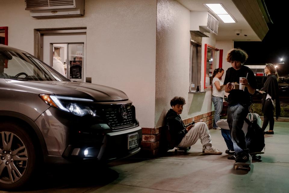 A photo of teenagers hanging out outside an In-N-Out burger