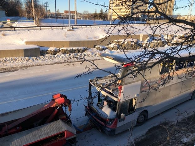 A tow truck pulls away a damaged OC Transpo bus from Westboro station on Jan. 12, 2019. The double-decker bus struck the shelter the day before.