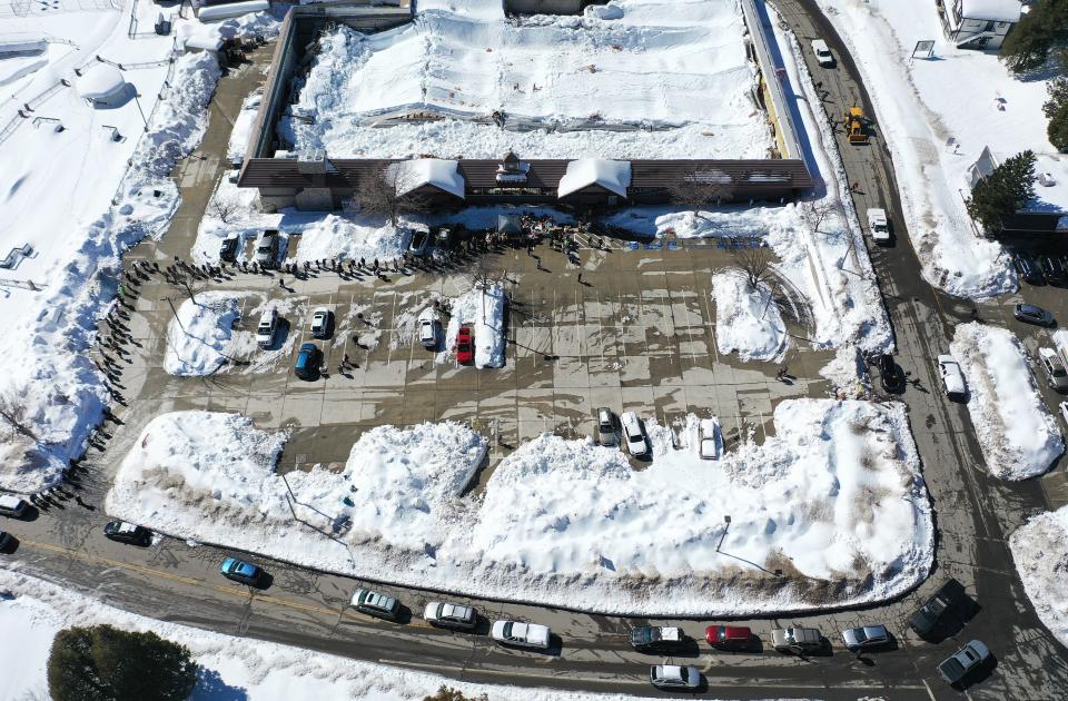 An aerial view of residents waiting in line to receive donated food outside the local grocery store (TOP C), which was severely damaged when its roof collapsed under the weight of several feet of snow, after a series of winter storms in the San Bernardino Mountains in Southern California on March 3, 2023 in Crestline, California. Some residents have been trapped in Crestline more than a week due to heavy snowfall while the grocery store was the main hub for food purchases in town. California Governor Gavin Newsom has declared a state of emergency due to winter storms for 13 counties including San Bernardino County and the California National Guard is assisting relief efforts in the mountains.