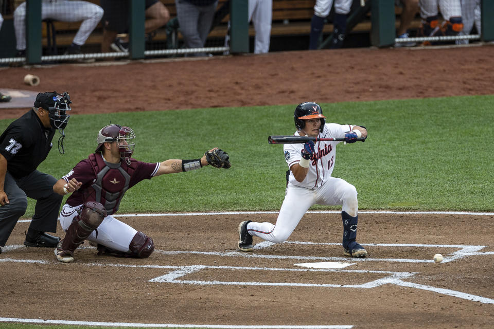 Virginia catcher Logan Michaels (12) SAC bunts the ball advancing Jake Gelof, not pictured, to second base against Mississippi State in the second inning during a baseball game in the College World Series Tuesday, June 22, 2021, at TD Ameritrade Park in Omaha, Neb. (AP Photo/John Peterson)