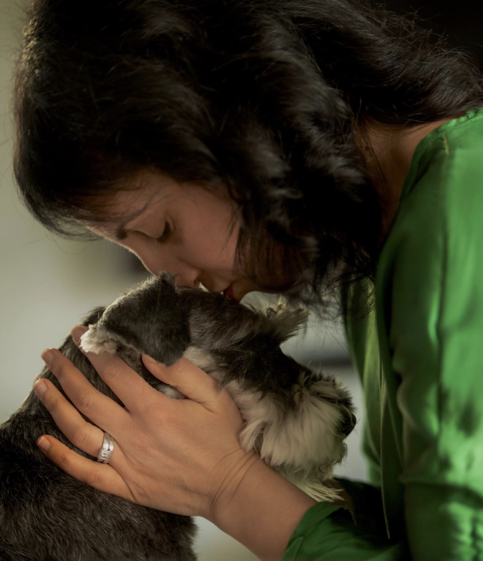 Photo shows Jo Cooper kissing the head of her dog Angus.