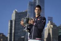 Novak Djokovic of Serbia poses with the champion's trophy in Central Park a day after winning the U.S. Open Championships men's tennis tournament in New York, September 14, 2015. REUTERS/Carlo Allegri