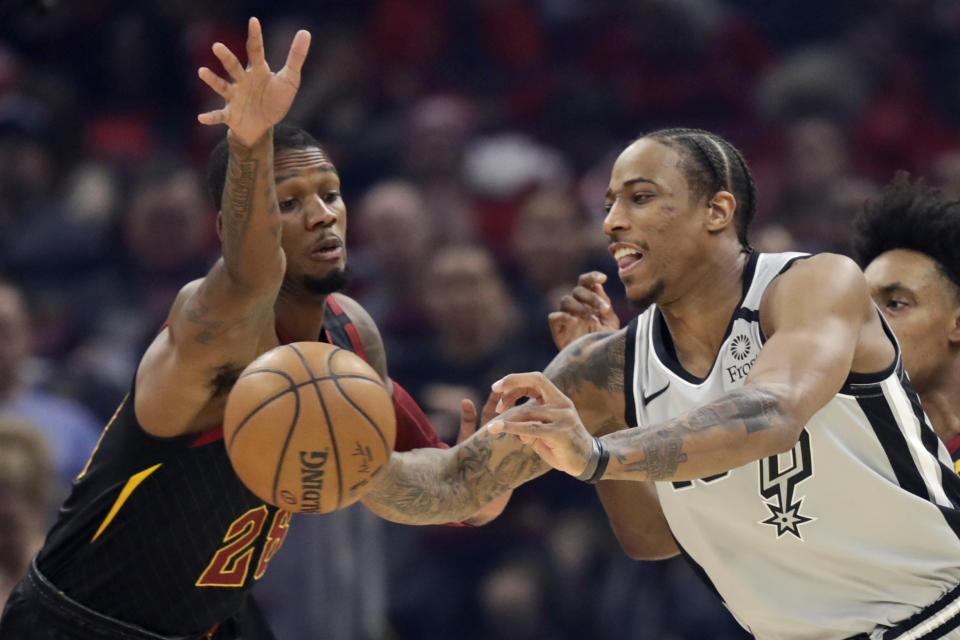San Antonio Spurs' DeMar DeRozan, right, passes against Cleveland Cavaliers' Alfonzo McKinnie in the first half of an NBA basketball game, Sunday, March 8, 2020, in Cleveland. (AP Photo/Tony Dejak)