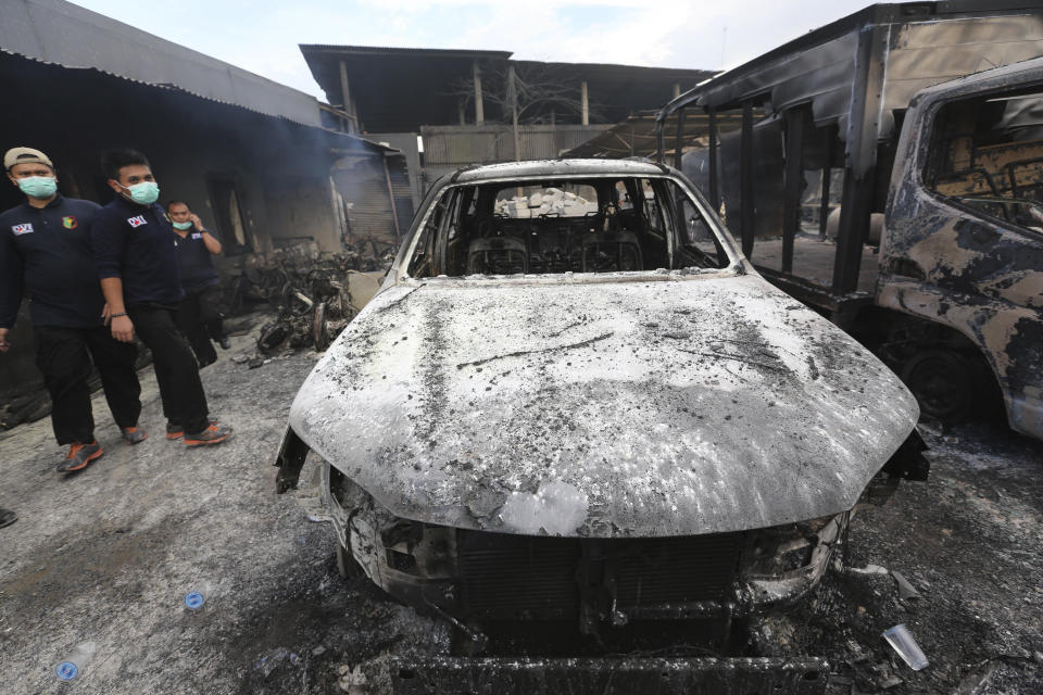 <p>Rescuers inspect burnt out cars at the site of an explosion at a firecracker factory in Tangerang, on the outskirt of Jakarta, Indonesia, Thursday, Oct. 26, 2017. The explosion and raging fire killed a number of people and injured dozens, police said. (Photo: Tatan Syuflana/AP) </p>