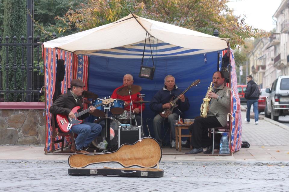 In this photo taken on Oct. 21 2012, street musicians play on the pedestrian-only Olha Kobylianska street in Chernivtsi, a city of 250,000 in southwestern Ukraine. Known as the Little Paris or, alternatively, the Little Vienna of Ukraine, Chernivtsi is a perfect place for a quiet romantic weekend trip and a crash course in the painful history of Europe in the 20th century. (AP Photo/Maria Danilova)