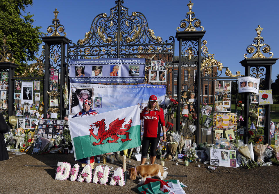 <p>Royal fans hold a Welse flag to remember the late Diana, Princess of Wales, outside Kensington Palace in London, Aug. 31, 2017. (Photo: Frank Augstein/AP) </p>