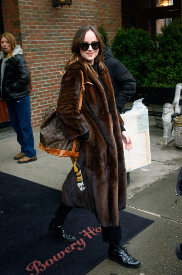 Dakota Johnson in brown fur coat with brown Louis Vuitton bucket