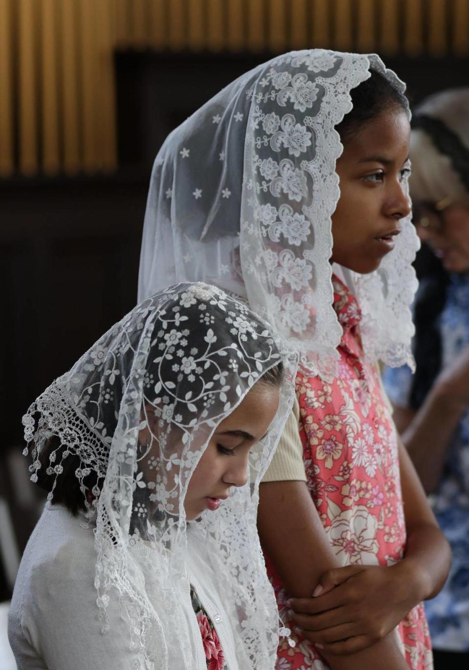 Young choir girls pray during the Traditional Latin Mass service at Our Lady of Belen Chapel, Sunday, July 30, 2023.